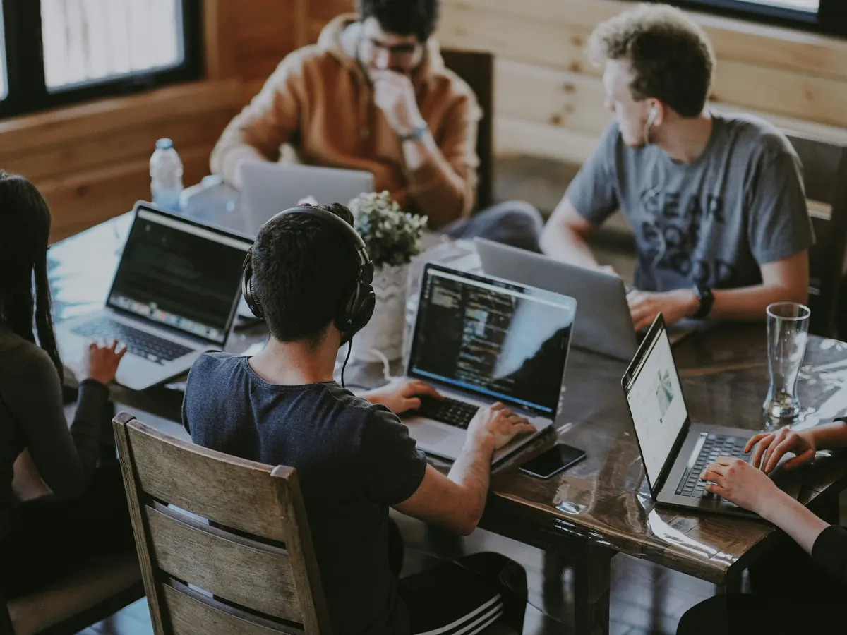 A team collaborating on laptops around a shared table
