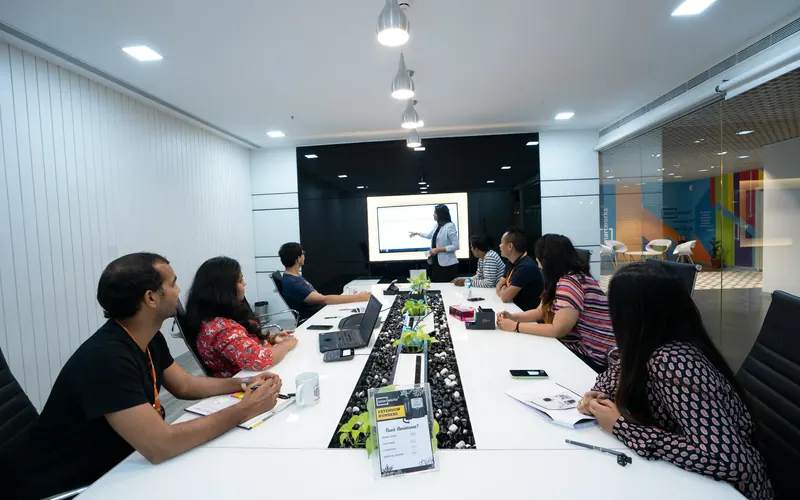 A presenter leading a training session for a team in a conference room